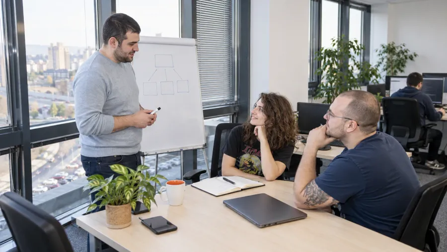 An Atom project lead sketching a system structure on a flip chart for two colleagues